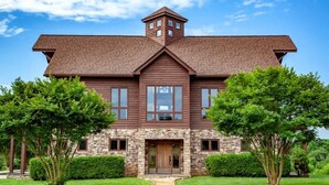 A large, two-story house with a stone foundation and a brown roof. - The Houses at Lumusa (Culpeper)