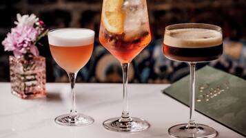 Trois verres contenant différentes boissons sont posés sur une table en marbre.