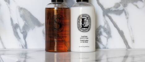 Two bottles of lotion on a marble countertop.