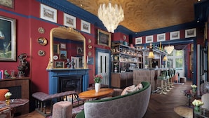 A bar area with a fireplace, seating, and a bar counter. - Bertrand's Townhouse (London)