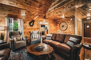 Ein gemütliches Holzinterieur mit einer Ledersofa, Sesseln und einem Couchtisch.