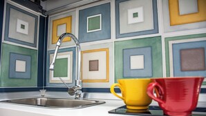 Une cuisine dotée d’un robinet moderne, d’un évier et de carreaux de crédence aux motifs géométriques et aux couleurs vives.