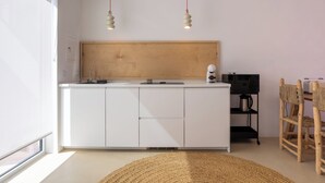 A modern kitchen with white cabinets, a wooden countertop, and two pendant lights. - CASA DO REGADIO - CASA 3, A country and sea retreat on the Alentejo coast, (Beja)