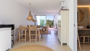 A modern kitchen with a dining area, large windows, and a view of greenery. - CASA DO REGADIO - CASA 3, A country and sea retreat on the Alentejo coast, (Beja)