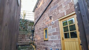 A stone building with a wooden door and a small window. - The Apple Store (Tarporley)