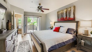 A bedroom with a bed, a ceiling fan, a painting, a nightstand, and a dresser. - 2bd/2ba North Scottsdale Condo (Scottsdale)