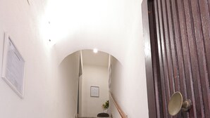 A marble staircase leading to a landing with a wooden door and a framed picture on the wall.