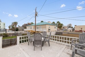 A balcony with outdoor furniture and a view of a residential area. - The Historic Kent House on Marisol (South Padre Island)