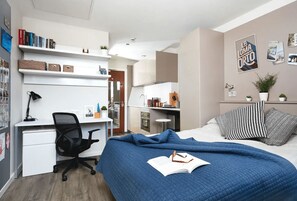 A bedroom with a bed, a desk, and a kitchenette. - Student Only Vita Crosshall Street (Liverpool)