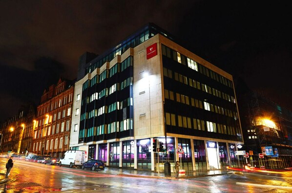 A modern building with a prominent sign, large windows, and a well-lit entrance area. - Student Only Vita Crosshall Street (Liverpool)