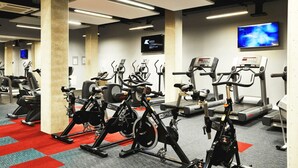 Un gimnasio con bicicletas estáticas, cintas de correr y máquinas de pesas.