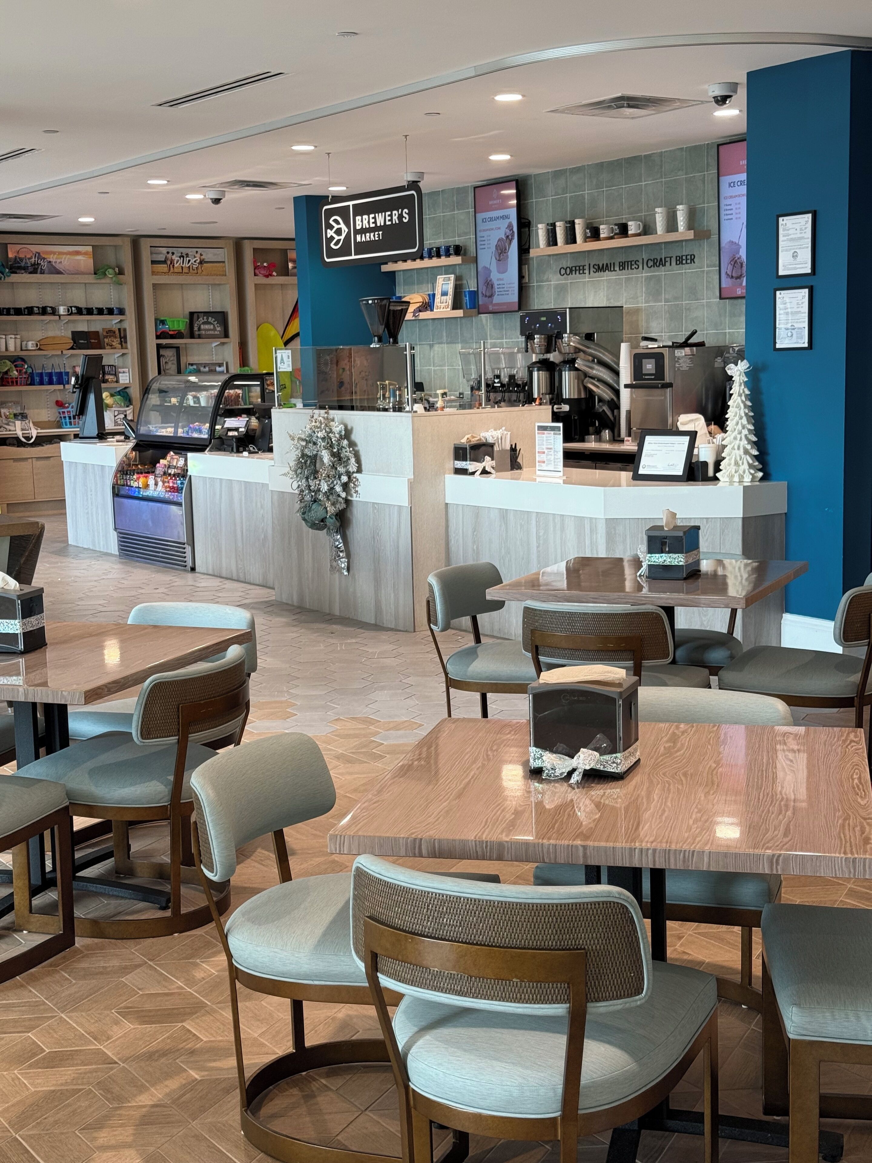A cafe with a counter, seating area, and a display of coffee and craft beer.