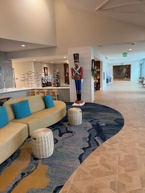A modern lobby with a curved seating area, a large nutcracker statue, and a Christmas tree. - Rare, Luxury, 3 Bedroom/2 Bathroom Oceanfront Condo in Myrtle Beach, SC (Myrtle Beach)