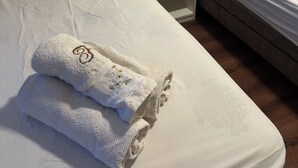 Une chambre d’hôtel avec deux lits, une table de chevet et une prise de courant fixée au mur.