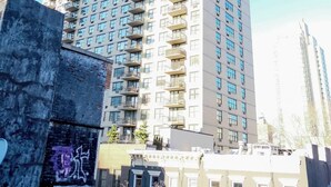 A tall residential building with multiple balconies and a clear sky. - Chic Urban Retreat: Duplex with Private Roof Deck (New York)