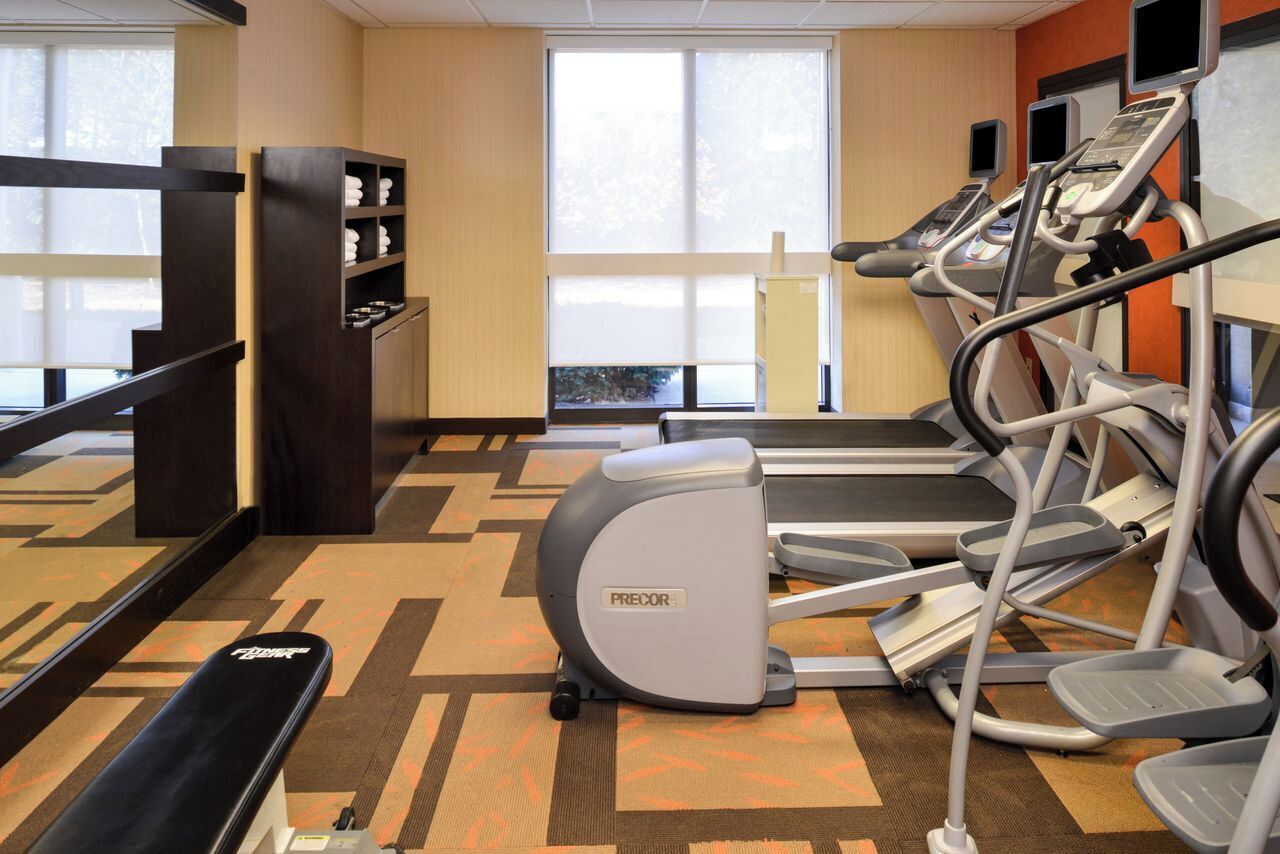 A gym with treadmills, a stationary bike, and a bench.