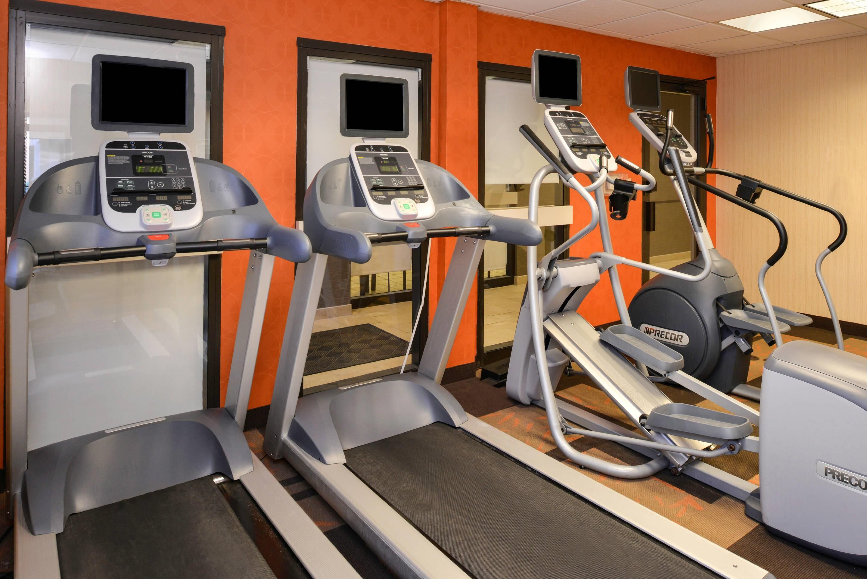 A gym with treadmills, ellipticals, and a Precor stationary bike.