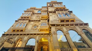 A multi-story building with ornate architectural details, including arched windows and decorative balconies. - The Rising Haveli (Jaisalmer)
