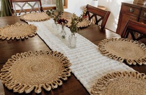 A dining table with a long white table runner and four round, fringe-ed placemats. - Peaceful 4-bedroom house in charming Clackamas (clackamas)