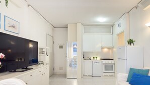 Une cuisine moderne avec des armoires blanches, un four encastré et un réfrigérateur.