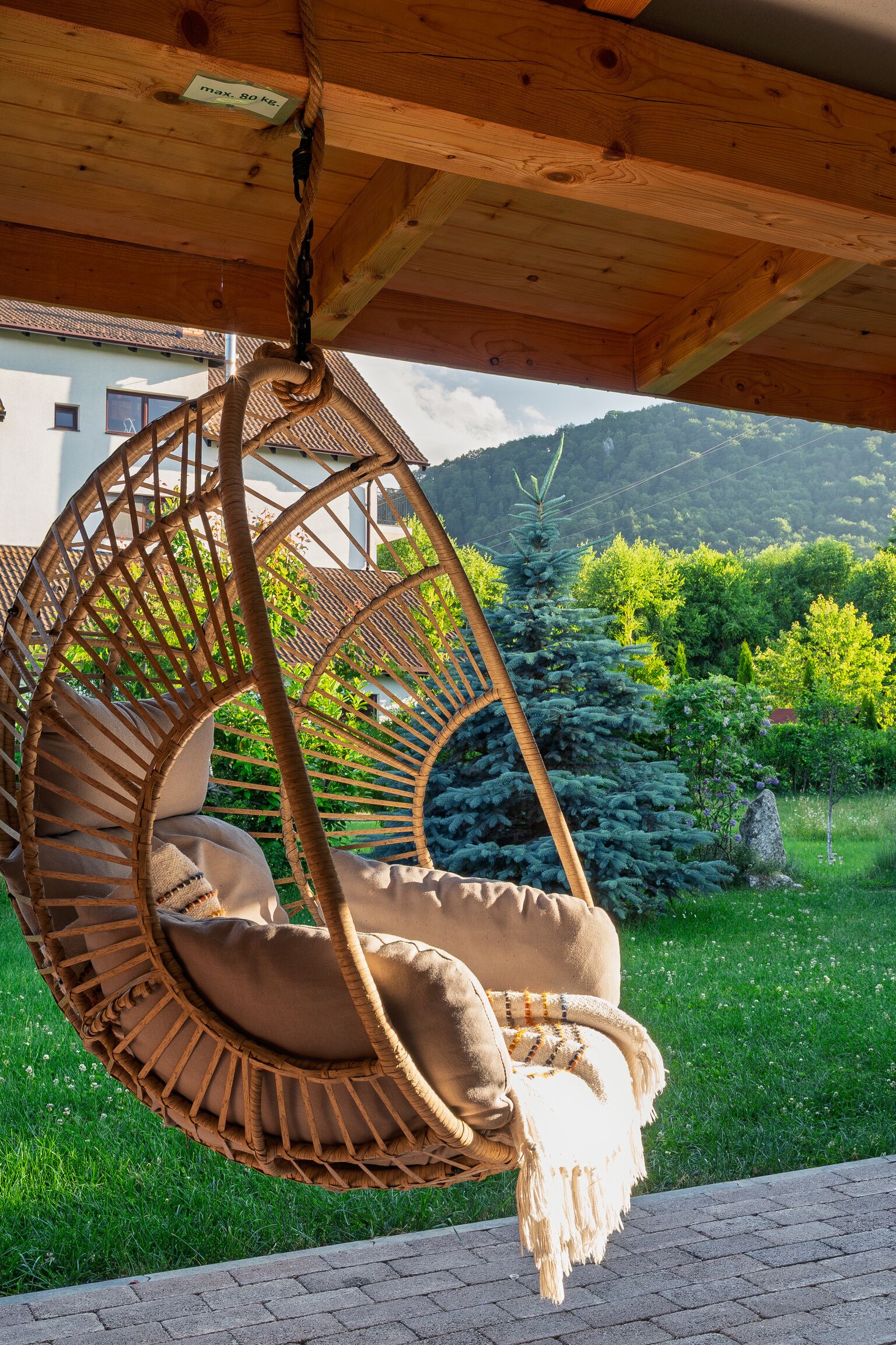 A wooden ceiling with a hanging chair.