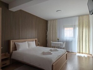 Habitación doble, balcón, vista al patio | Espacio para trabajar con laptop y tabla de planchar con plancha