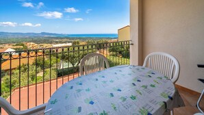 Un balcón con mesa y sillas, con vistas a un paisaje pintoresco.
