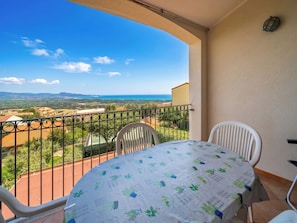 Ein Balkon mit Tisch und Stühlen mit Blick auf eine reizvolle Landschaft.