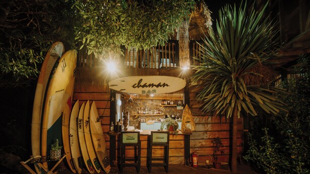 A tiki bar with surfboards and a wooden interior. - Ocean View Hot Tub Suites (Pichilemu)
