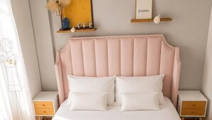Una cama bien hecha con sábanas blancas, dos mesitas de noche y un cabecero.