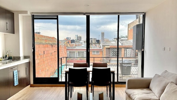 A modern living room with a dining area, large windows, and a city view. - San Felipe (Bogotá)