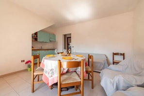 A compact living space with a dining area, kitchenette, and a bed. - San Teodoro Flat Steps From the Beach (San Teodoro)