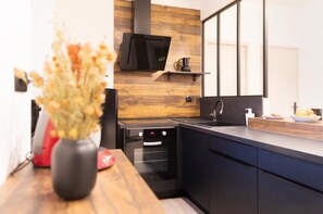 Een moderne keuken met inbouwapparatuur, een houten spatwand en een grote spiegel.