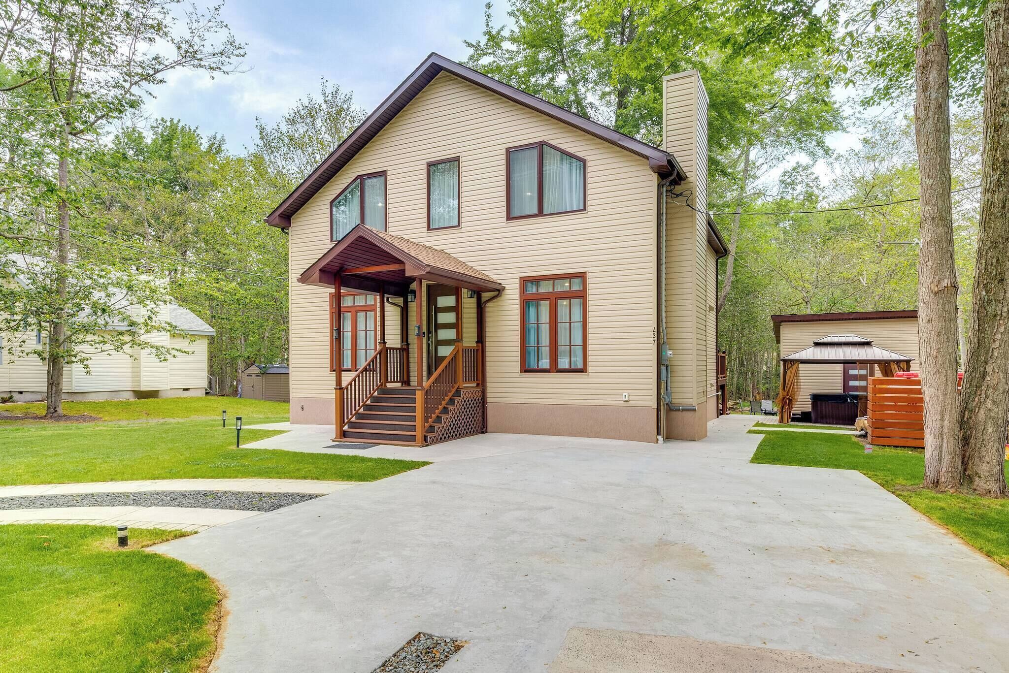 A two-story house with a front porch, a covered entryway, and a driveway leading to the garage.