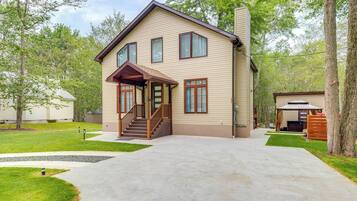 A two-story house with a front porch, a covered entryway, and a driveway leading to the garage.