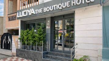 Entrada de un hotel con un cartel que dice 'LICHYA THE BOUTIQUE HOTEL'.
