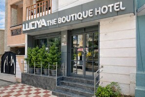 Entrada de un hotel con un cartel que dice 'LICHYA THE BOUTIQUE HOTEL'.