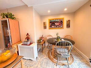 A dining area with a round table, two chairs, a small side table, and a cabinet with a plant. - Premium Private Home w/ Parking, Yard, Pets Welcome! Near Newark Airport & NYC (Union)