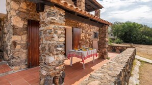 Un edificio de piedra con un patio empedrado y una mesa lista para comer.