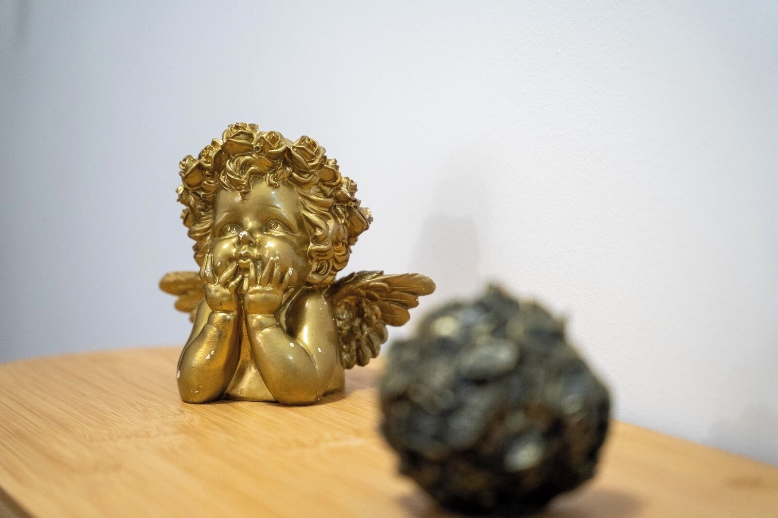 Une statuette d’ange doré, aux ailes déployées, posée sur une surface en bois.