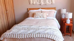 A bedroom with a wooden bed, a macrame wall hanging, and two bedside lamps. - Bright & Spacious Apartment with Mexico City Views – Polanco (Ciudad de México)