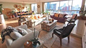A spacious living room with a large window, a dining area, and a view of the city skyline. - Bright & Spacious Apartment with Mexico City Views – Polanco (Ciudad de México)