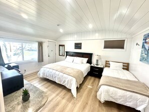 Une chambre avec deux lits, un bureau et une fenêtre.