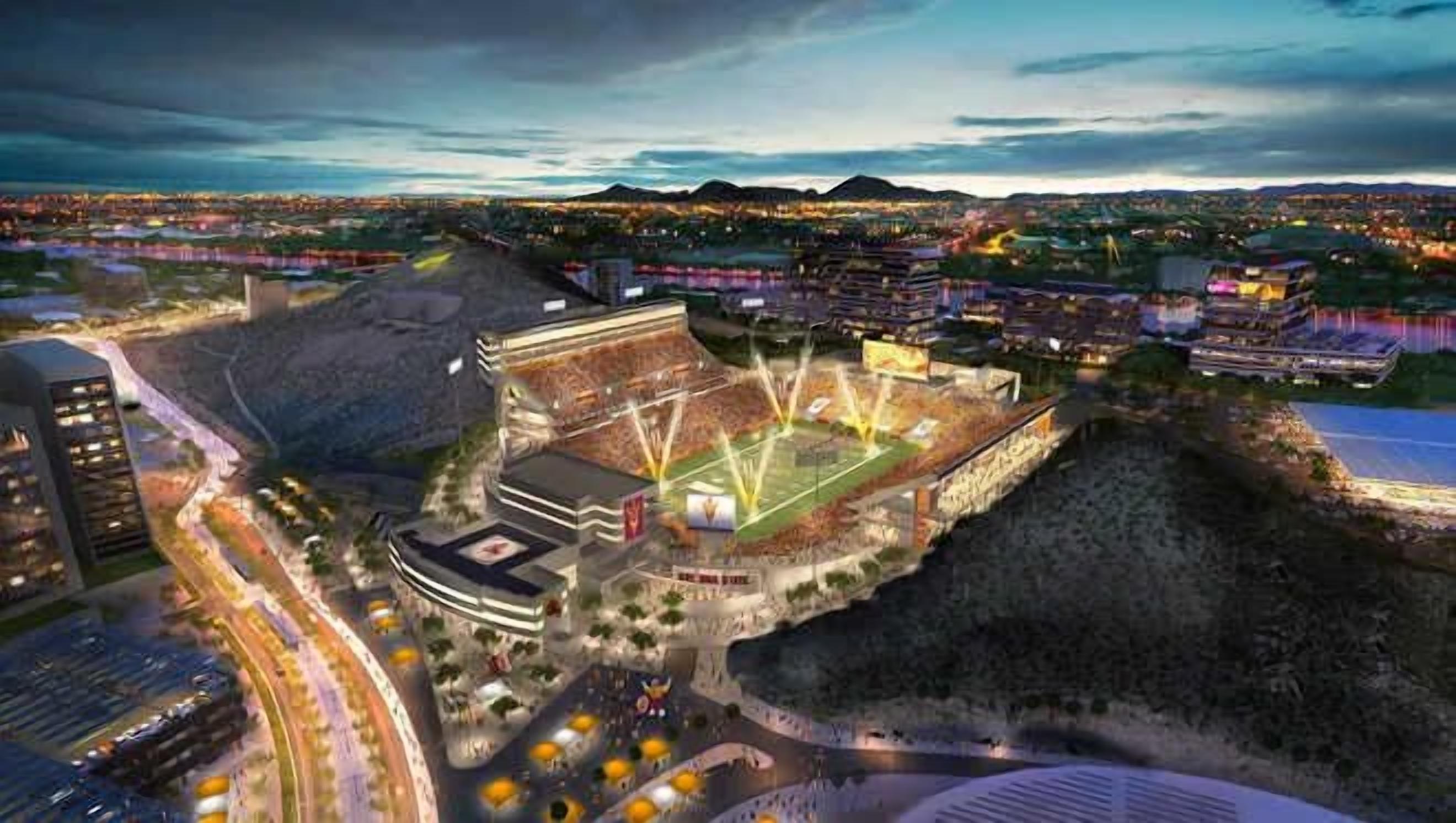 Uno stadio con un ampio campo centrale, circondato da gradinate per gli spettatori e un'area di parcheggio.