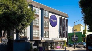 A Marriott Vacation Club building with a large purple Pulse logo, a storefront, and a green building with 'FREDDIE BILLY ROYALS' signage in the background. - Enjoy all San Francisco has to offer for Super Bowl Weekend! (San Francisco)
