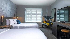 A hotel room with two beds, a desk, a chair, and a large window with blinds. - Enjoy all San Francisco has to offer for Super Bowl Weekend! (San Francisco)