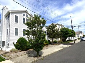 A two-story residential building with a front yard and a sidewalk. - Steps from the Sand, Ultimate Coastal Retreat (Ocean City)