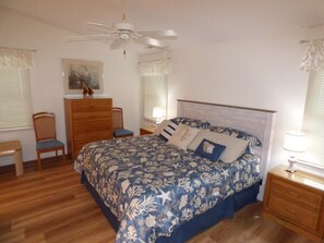 A bedroom with a bed, wooden dresser, chair, nightstand, and ceiling fan. - Steps from the Sand, Ultimate Coastal Retreat (Ocean City)