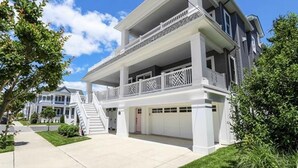 Une maison à deux étages avec un porche abrité et un garage.