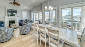 Un amplio salón con chimenea, asientos cómodos y grandes ventanales con vistas a la ciudad.